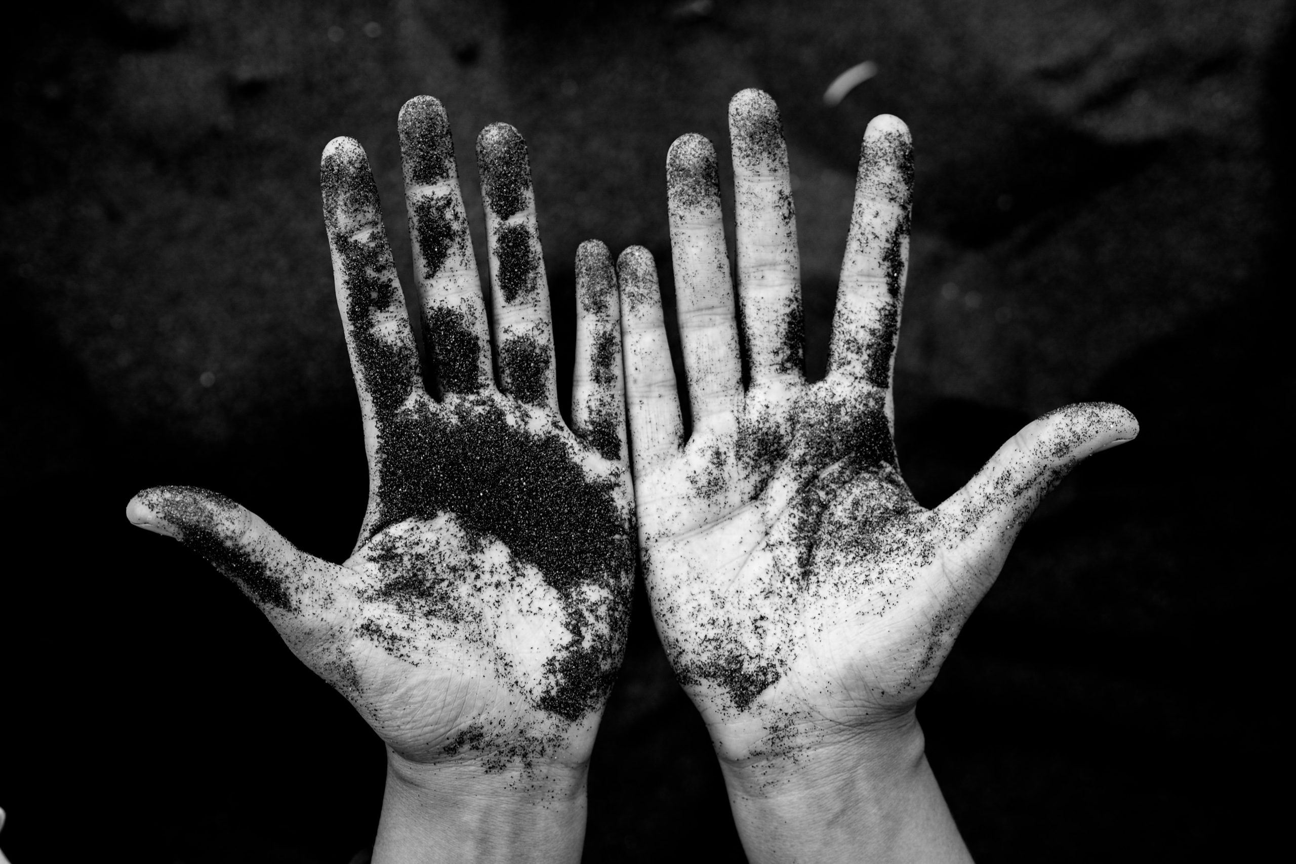 black-and-white photo of hands covered in ashes